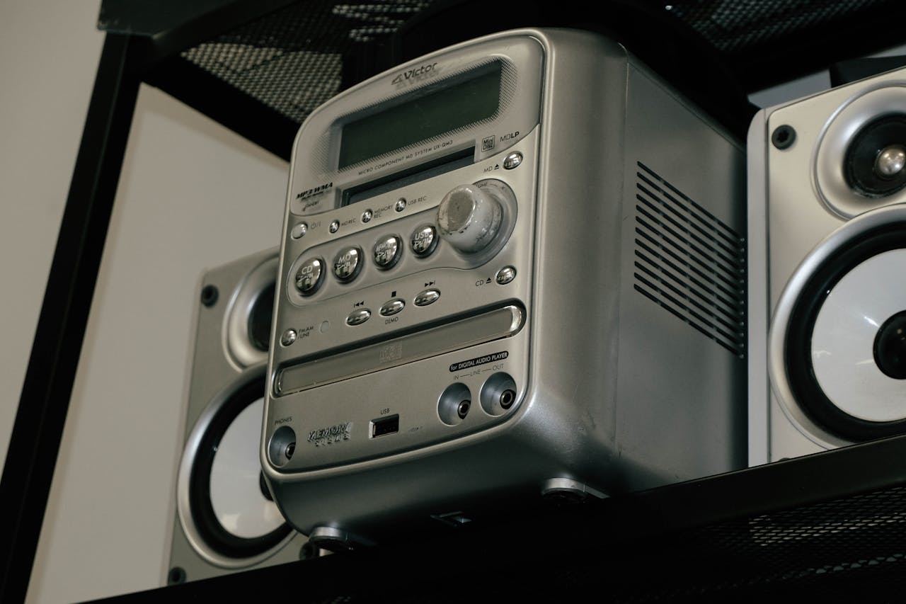 A classic silver stereo system with speakers on a shelf, showcasing retro design.
